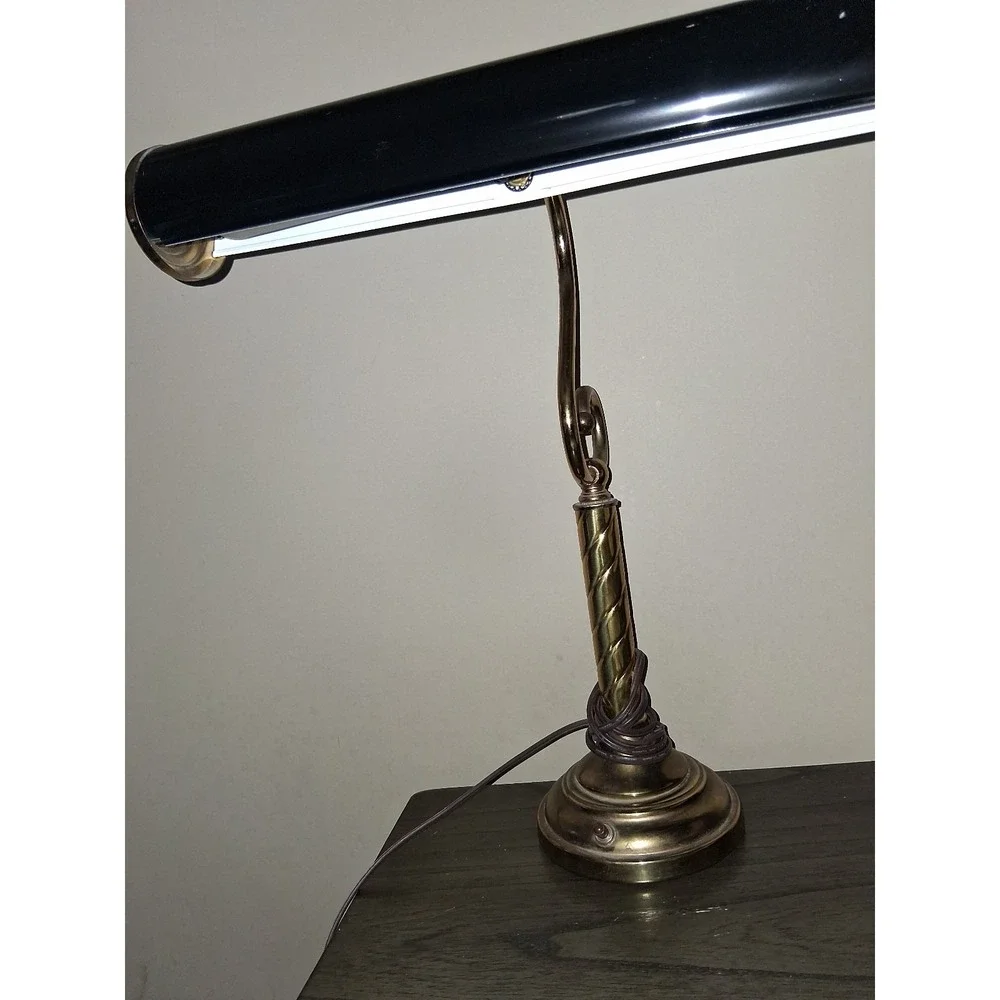 Vintage brass tone desk lamp with elegant scroll arm and classic piano light